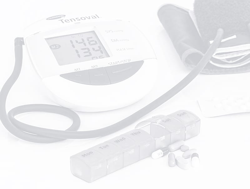 Schwarz-Weiß-Bild von einem Blutdruckmessgerät und Tabletten